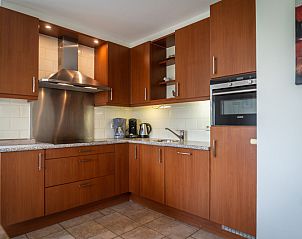 Modern kitchen in Villa 304, De Koog, Texel with wooden cabinets and complete kitchen appliances.