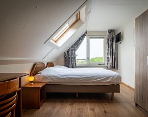 Spacious bedroom in Villa 304, De Koog, Texel with skylight and beautiful views of nature.