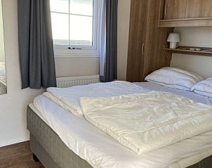 Comfortable bedroom in Chalet Bregkoog 255, De Koog, Texel with large window and lots of natural light, ideal for a good night's sleep.