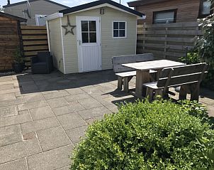 Spacious terrace at Chalet Bregkoog 255, De Koog, Texel with wooden garden furniture, perfect for outdoor dining and enjoying nature.