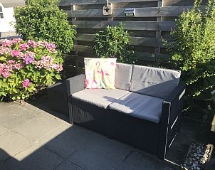 Sunny terrace with comfortable seating in Chalet Bregkoog 255, De Koog, Texel, surrounded by colorful flowers for a perfect vacation.