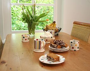 Cozy dining area in Pauwenhof Texel, De Koog with delicacies and flowers.