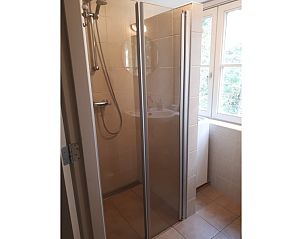 Spacious shower in Pauwenhof Texel, De Koog with modern glass doors and natural light.