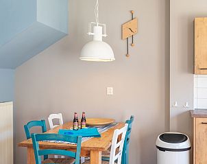 Dining area in Landgoed Springtij - Koetshuis 3, vacation home De Koog, Texel with wooden table and colorful chairs.