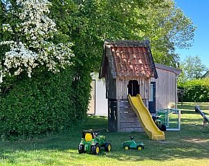 Child-friendly garden of Landgoed Springtij - Koetshuis 3, vacation home De Koog, Texel with playhouse and toys.