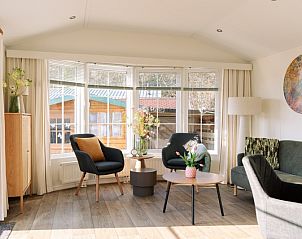 Bright living room in Chalet Bregkoog 24, De Koog, Texel, with comfortable chairs and large windows.
