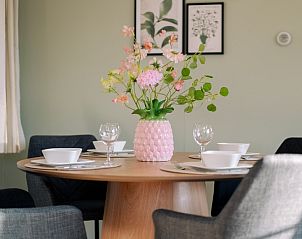 Stylish dining table with flowers in Chalet Bregkoog 24, De Koog, Texel, at Chaletpark Bregkoog.