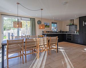 Modernes Esszimmer und Kche im Ferienhaus Dennenbries, De Koog, Texel mit Blick in den Garten.