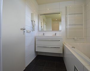 Stilvolles Badezimmer im Ferienhaus Stappeland 171 in De Koog, Texel mit Doppelwaschbecken und Badewanne.