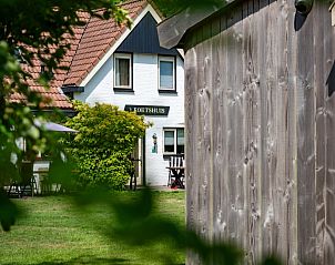Landgoed Springtij - Koetshuis 2 in De Koog, Texel offers a charming vacation home with green surroundings and an inviting terrace.