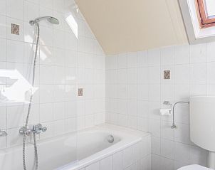 Bright bathroom with bath in Landgoed Springtij - Koetshuis 2, vacation home in De Koog, Texel, for a relaxing experience.