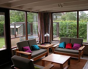 Sunny conservatory in Bungalow Oud Vredelust 75, De Koog, Texel, overlooking the garden.
