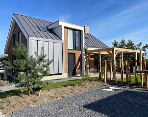 Seitenansicht von Duinvilla Wellness 5 in De Koog, Texel, Ferienhaus mit moderner Architektur und groer Veranda.