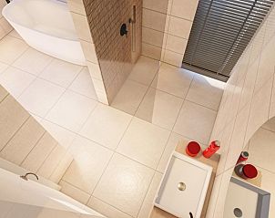 Stilvolles Badezimmer mit Badewanne und Doppelwaschbecken in der Ferienwohnung Duinvilla Wellness 5 in De Koog, Texel.