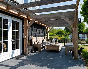 Veranda van vakantiehuis Residence Rustiek in De Koog, Texel met houten meubels.