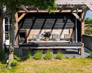 Gezellig terras bij Residence Rustiek in De Koog, Texel met zitbank en tafels.