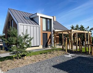 Exterior of Duinvilla Wellness 6, Texel, with wooden elements and green surroundings.