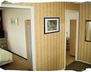 Gang met toegang tot slaapkamers in vakantiewoning De Koog, Texel, met warme, uitnodigende sfeer.