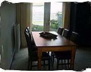 Eetkamer met grote tafel in vakantiewoning De Koog, Texel, ideaal voor gezellige maaltijden en bijeenkomsten.