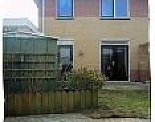 Zonnige achtertuin van vakantiewoning De Koog, Texel, met terras en veel privacy voor buitenplezier.