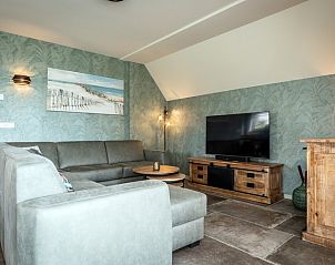 Stilvolles Wohnzimmer des Landhuis Ferienhauses in De Koog, Texel mit bequemem Sofa und Fernseher.