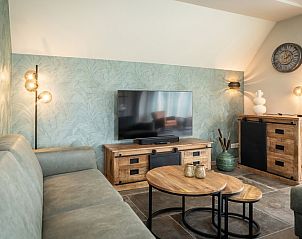 Gemtliche Sitzecke im Ferienhaus Landhuis in De Koog, Texel, mit Flachbildfernseher und Holzmbeln.