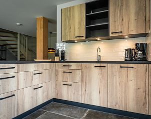 Cozy dining area in Holiday home in De Koog, Texel, with wooden table and chairs.