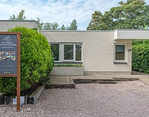 Entrance to Zilte Bries vacation home in De Koog, Texel with welcome sign and green surroundings.