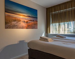 Attractive bedroom in Zilte Bries vacation home on Texel, De Koog with art on the wall.