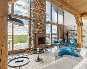 Cozy living room with fireplace in Holiday home in De Koog Texel, offers views of the nature of the Wadden Islands.