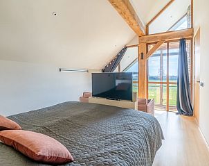 Bedroom with large window and view of nature in Holiday home in De Koog Texel, for a restful stay on the Wadden Islands.