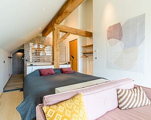 Bedroom with wooden beams and artistic decoration in Holiday home in De Koog Texel, for a unique stay on the Wadden Islands.