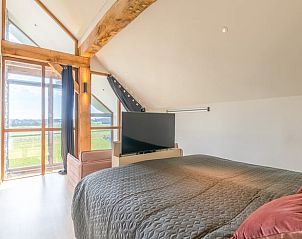 Bedroom with TV and nature view in Holiday home in De Koog Texel, offers relaxation on the Wadden Islands.