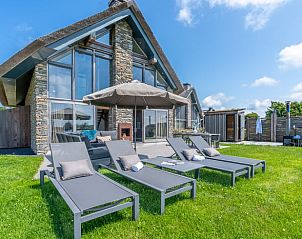Spacious garden with deck chairs and parasol in Holiday home in De Koog Texel, ideal for sunbathing on the Wadden Islands.