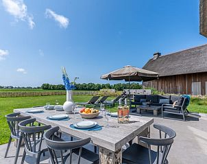 Outdoor area with large dining table in Holiday home in De Koog Texel, ideal for cozy meals on the Wadden Islands.