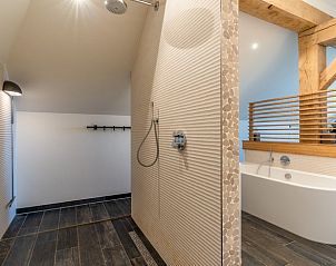 Modern bathroom with walk-in shower and bathtub in Holiday home in De Koog, Texel.