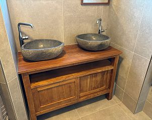 Double sink in bathroom of Stormvogel, vacation home De Koog, Texel with wooden furniture.