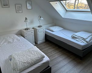Bedroom in Stormvogel, vacation home De Koog, Texel with two single beds and window.