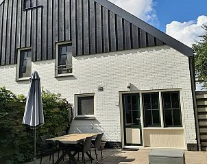 Sunny terrace with garden furniture at vacation home Stormvogel in De Koog, Texel.