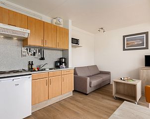 Gezellige binnenruimte van B Appartement Comfort 4 in De Koog, Texel, compleet met moderne keuken en comfortabele zithoek.