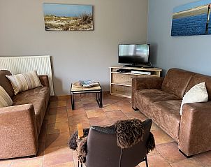 Gezellige woonkamer in Koetshuis 2, vakantiehuis De Koog, Texel met comfortabele banken.