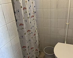 Badkamer in Koetshuis 2, Texel met douche en kleurrijk douchegordijn.