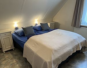 Ruime slaapkamer met tweepersoonsbed in Koetshuis 2, Texel.