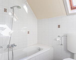 Bathroom with bath and shower in Koetshuis 3 vacation home, De Koog, Texel.