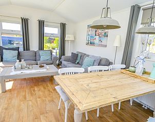 Cozy living room in Chaletpark Bregkoog - Chalet Bregkoog 215 Zandhuisjes, De Koog, Texel, with comfortable sofas and lots of light.