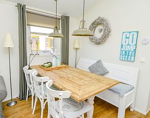 Dining area in Chaletpark Bregkoog - Chalet Bregkoog 215 Zandhuisjes, De Koog, Texel, with wooden table and cozy atmosphere.