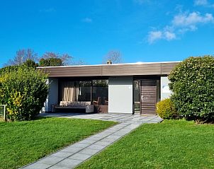 Front view of Orchismient 20, a modern vacation home in De Koog, Texel with green garden and terrace.