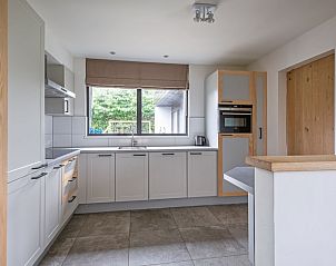 Modern kitchen in Orchismient 20, vacation home De Koog, Texel, with spacious countertops and views of the garden.