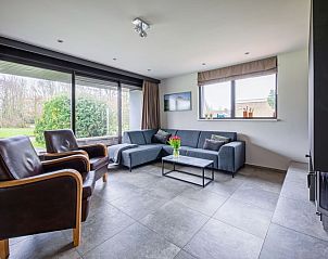 Bright living room in Orchismient 20, vacation home De Koog, Texel, with modern furniture and garden views.