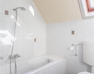Bright bathroom with bath in Landgoed Springtij - Koetshuis 1, vacation home in De Koog, Texel.